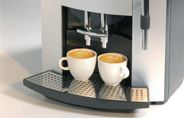 Zwei Kaffeetassen unter Kaffeemaschinenauslauf